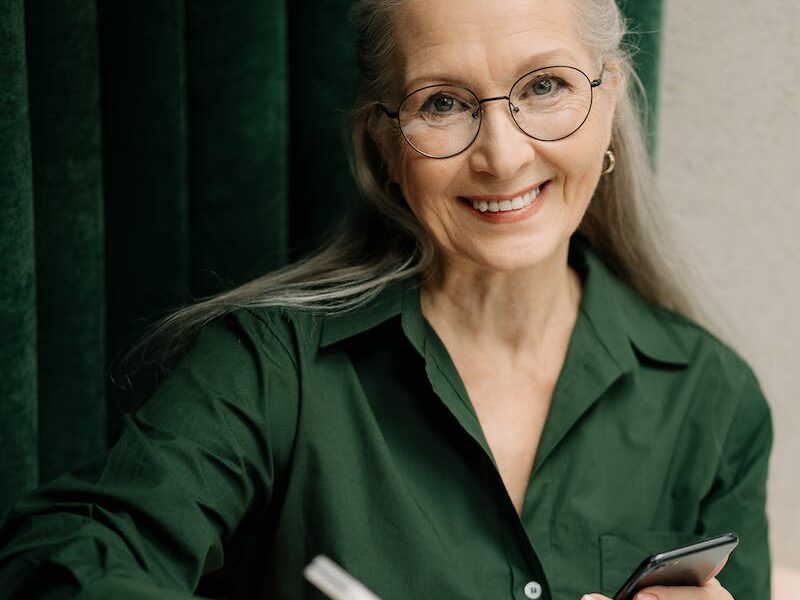 Woman in Green Long Sleeve Shirt Holding Smartphone