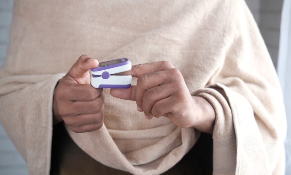 person in gray sweater holding white and blue smartphone